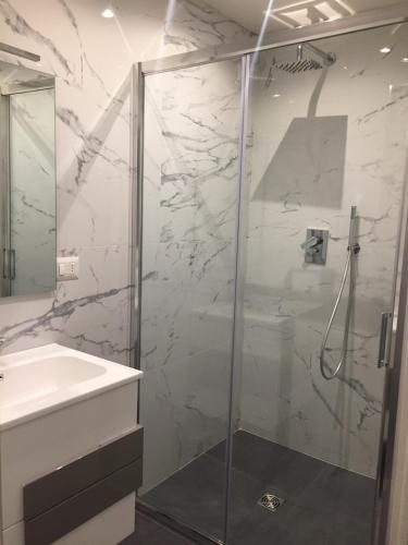 uma casa de banho com uma cabina de duche em vidro e um lavatório. em Appartamento con vista em Milão