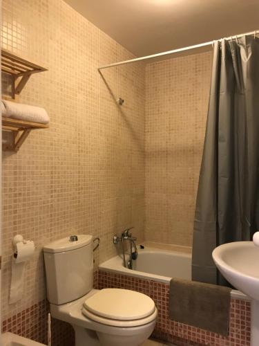 uma casa de banho com um WC, uma banheira e um lavatório. em Apartamento Coral Beach em Torrox Costa