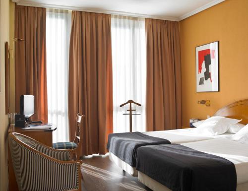 a hotel room with two beds and a window at Hotel Majadahonda in Majadahonda