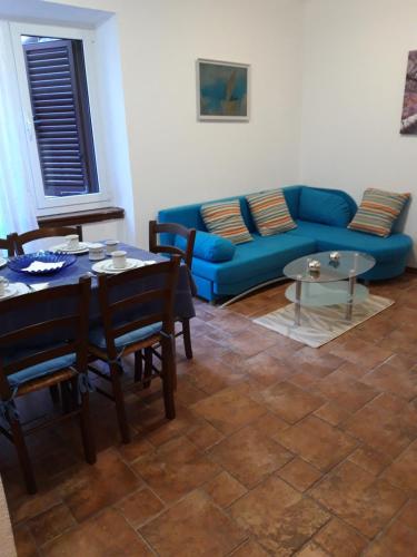 a living room with a blue couch and a table at Apartment Porat in Rovinj