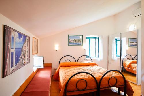 a bedroom with a bed with an orange comforter at Palazzo Della Marra in Ravello