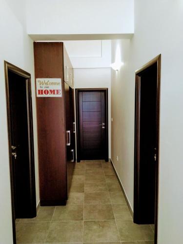 a hallway with two doors and a sign that reads home at Rooms & Apartments Vukasović in Kotor