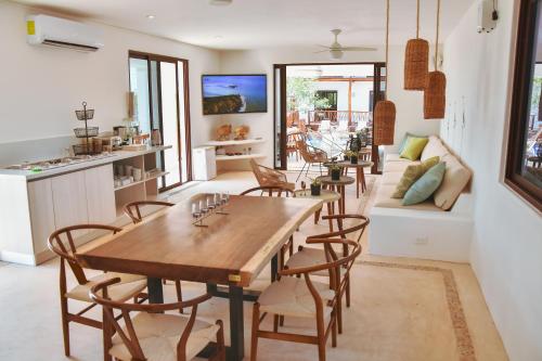 a kitchen with a table, chairs, and a refrigerator at Hotel Casa HX - Adults Only in Holbox Island