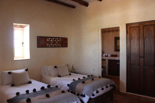 a room with three beds in a room with a window at Riad Sanam - Adults only in Essaouira