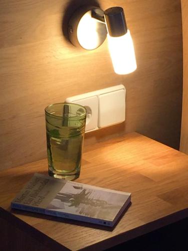 a glass of water and a book on a table at LICHTECK - Helle Ferien in Breitenberg