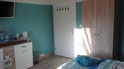ein Schlafzimmer mit grünen Wänden, einem Bett und einem Fenster in der Unterkunft Gästezimmer am Deister in Springe
