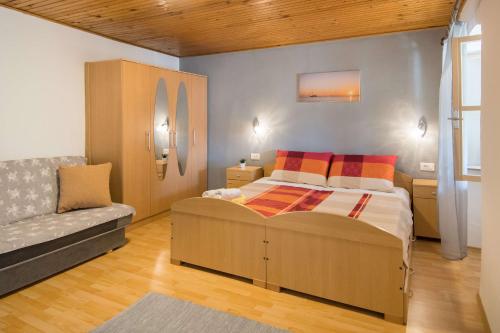a bedroom with a bed and a couch at Holiday Home Giovanni Vabriga with private Jacuzzi in Vabriga