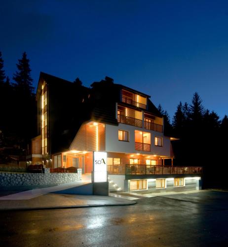 a building with a sign in front of it at night at Hotel Soa in Žabljak