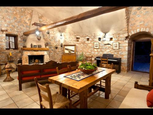 a living room with a wooden table and a fireplace at Arapakis Historic Castle in Pirgos Dhirou