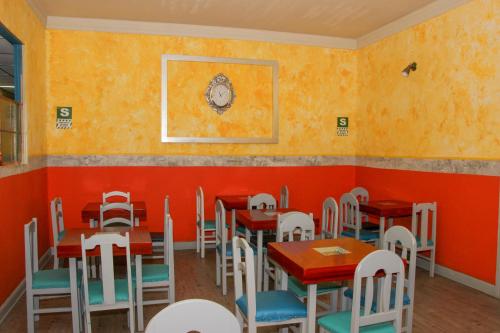 a restaurant with orange walls and tables and chairs at Hostal Los Balcones de Moral y Santa Catalina in Arequipa