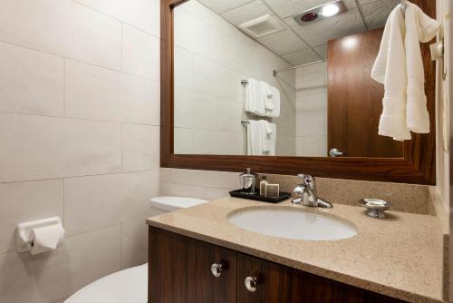 a bathroom with a sink and a mirror and a toilet at Alta's Rustler Lodge in Alta