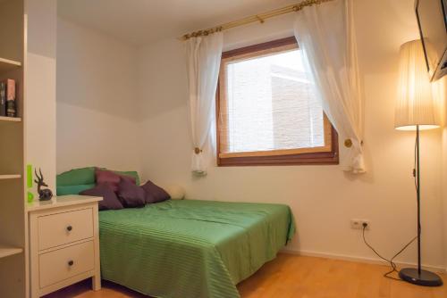 因斯布魯克的住宿－Apartment FreiRaum，一间卧室设有一张绿色的床和一个窗户。
