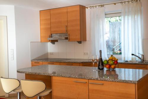 a kitchen with wooden cabinets and a counter with fruit and wine glasses at Apartment FreiRaum in Innsbruck
