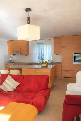 a living room with a red couch and a kitchen at Apartment FreiRaum in Innsbruck