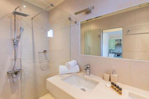 a bathroom with a sink and a shower and a mirror at Ziogas Luxury Apartments in Dassia