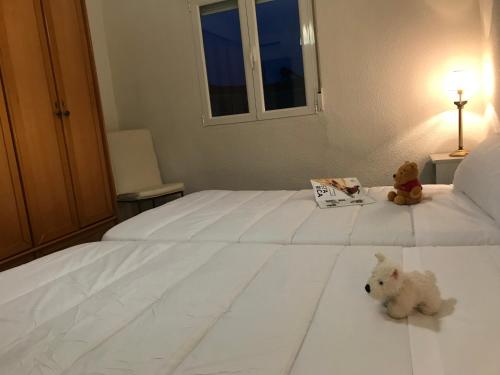 two teddy bears sitting on top of a white bed at Fercamar Costacabana in Almería