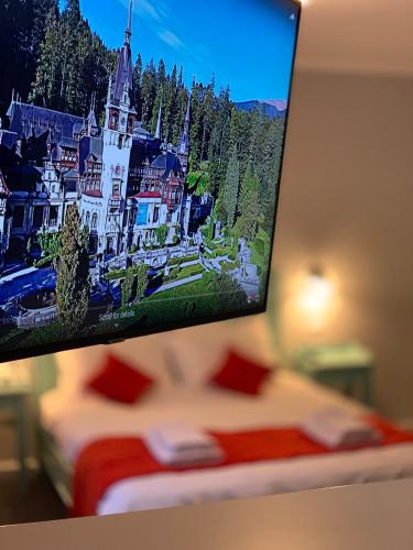 a tv hanging on a wall above a bed at Vila De Argint Aleea Pelesului Nr 2 in Sinaia