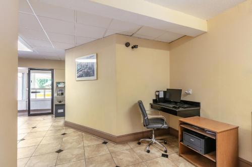 an office with a desk with a computer and a chair at Red Carpet Inn - Stamford in Stamford