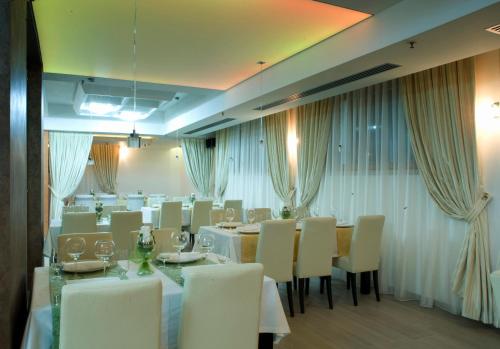 a dining room with white tables and white chairs at Hotel Soa in Žabljak