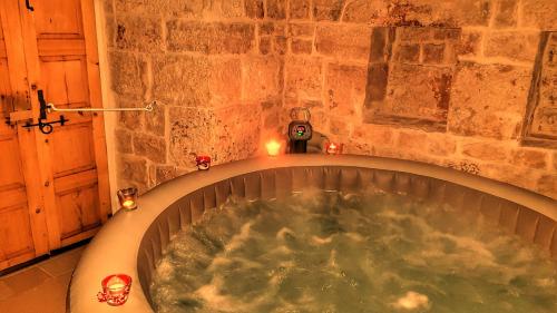 a bath tub in a room with candles in it at Trullo Suite in Cisternino