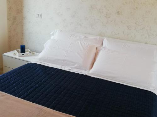 a bed with white sheets and a blue mattress at H & B Corte Ponti in Vermezzo