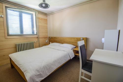a bedroom with two beds and a desk and a window at Gorski vrt in Novi Sad
