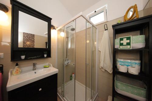 uma casa de banho com uma cabina de duche em vidro e um lavatório. em Charming Cottage near Tavira em Juliãos