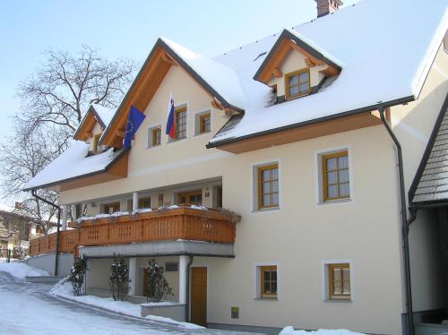 une maison recouverte de neige avec un balcon dans l'établissement Boutique Hotel Loka, à Škofja Loka