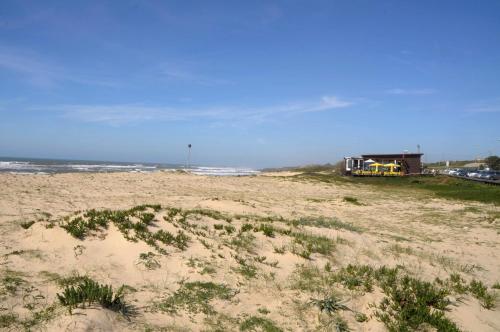 a beach with a truck in the sand and the ocean at Beach House, Labruge, Porto in Labruge