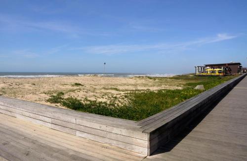 a boardwalk next to a beach with a yellow truck at Beach House, Labruge, Porto in Labruge