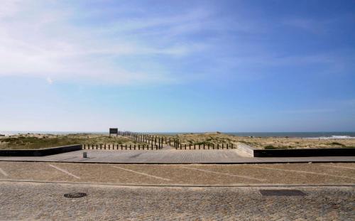 a fence on the beach with the ocean in the background at Beach House, Labruge, Porto in Labruge