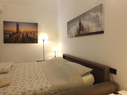 a bedroom with a bed and two pictures on the wall at Casa Amico Mare in Loano