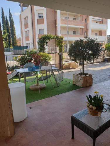 a patio with a table and a picnic table in a courtyard at B&B Domus Benedicta in Assisi