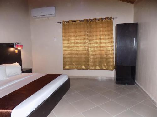 a bedroom with a large bed and a window at Posh Apartments Business Hotel in Ikeja