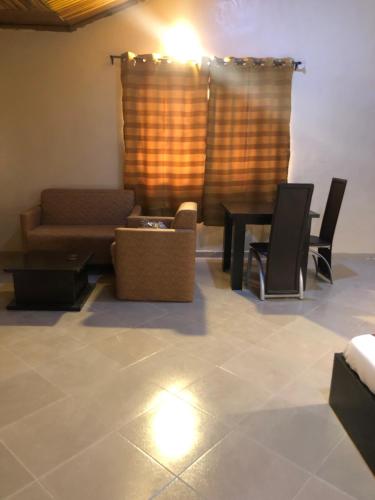 a living room with a couch and chairs at Posh Apartments Business Hotel in Ikeja