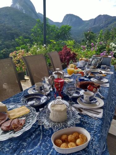 a blue table with food on it with mountains in the background at Zen in Itaipava