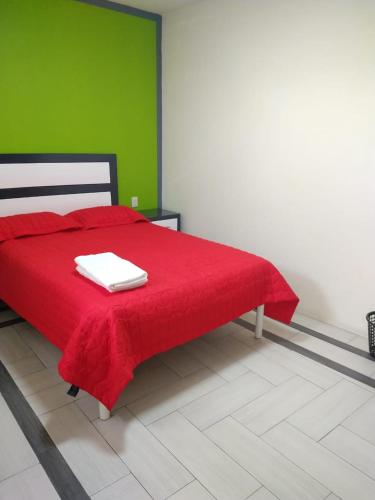 a bedroom with a red bed with a red blanket at Hotel del Rosario in Zacatlán