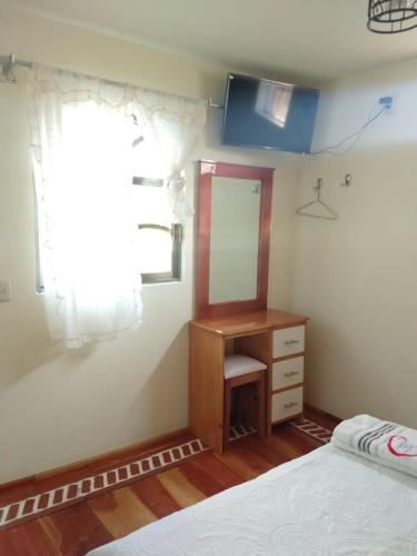 a bedroom with a bed and a desk and a window at Hotel del Rosario in Zacatlán