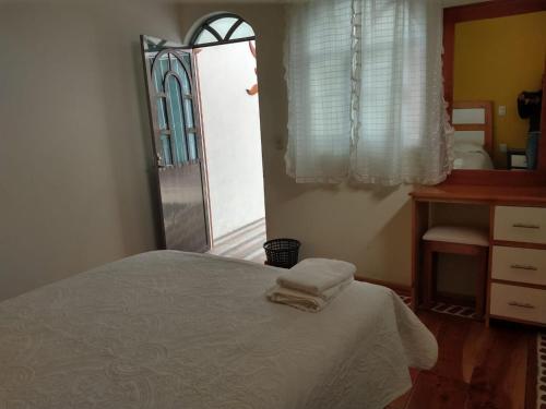 - une chambre avec un lit et 2 serviettes dans l'établissement Hotel del Rosario, à Zacatlán