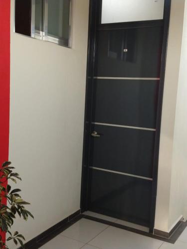 a black door with shelves in a room at Hotel del Rosario in Zacatlán