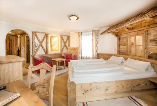 a bedroom with two beds and a table and chairs at Familien- und Vitalhotel Mühlpointhof in Lofer