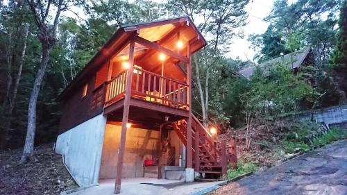 a cabin in the woods with a large deck at るり渓フォレストコテージｂ-6号棟岸本邸 in Nantan city