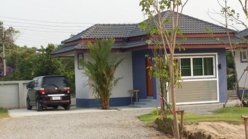 a car parked in front of a small house at Araya Cottage in Ban Bung Thap Tae (1)