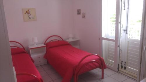 a small bedroom with two beds and a window at Villa Sara Timpi Russi in Sciacca