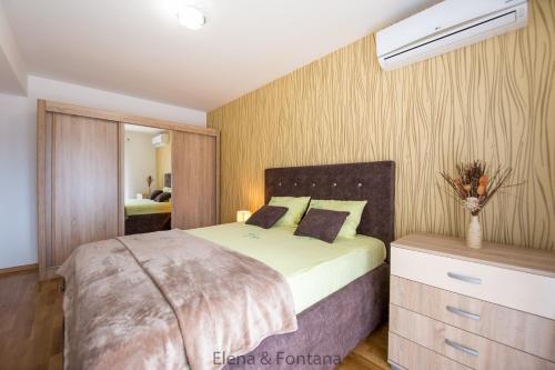 um quarto com uma cama com uma cómoda e um espelho em Elena&Fontana Apartment em Budva