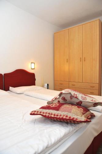 a bedroom with a white bed with a wooden cabinet at Albergo Stelvio in Bormio