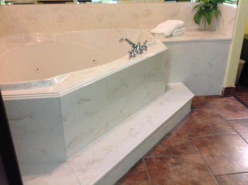 a white bath tub with a faucet in a bathroom at Scottish Inns & Suites Timber Creek, Houston, TX in Houston