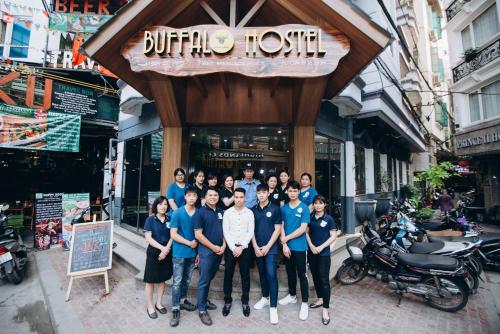 a group of people posing for a picture in front of a building at Hanoi Buffalo Hostel in Hanoi