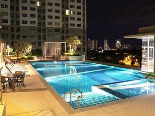 a swimming pool on the roof of a building at night at Lumpini Vacation Apartment in Pattaya North