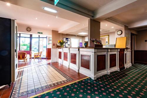 un vestíbulo de un hotel con bar y mesa en OYO Paddington House Hotel, en Warrington